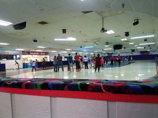 People enjoying roller skating and socializing at Pelican Underground Llc, with snacks and games in the background.
