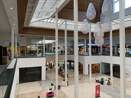 Pelican Underground Llc’s neat plumbing work is shown in a busy, modern mall with shops and people nearby.