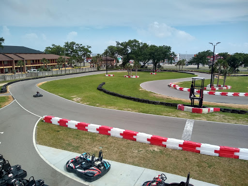 Pelican Underground Llc shows a fun and active go-kart track, with racers getting ready and one kart moving fast on the course.