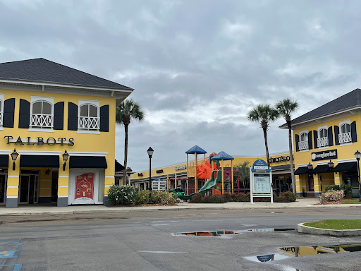 Pelican Underground Llc offers pipe repair in a quiet shopping plaza with stores and a playground, but no people are around.
