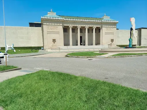 Pelican Underground Llc fixes vertical pipes using trenchless repair in a public building with sculptures out front.