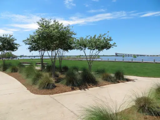 A calm park by water shows a nice place to rest after pipe work done by Pelican Underground Llc.