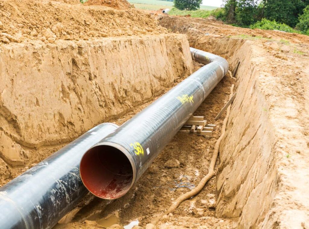 Pelican Underground Llc working on trenchless pipe repair for a new pipeline in a rural area. Safe, efficient progress shown.