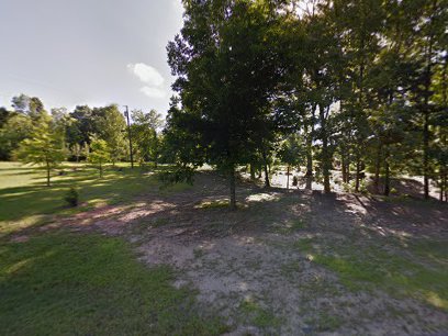 A quiet yard, like ones Pelican Underground Llc helps fix, is shown above spots where pipes need repair below the grass.