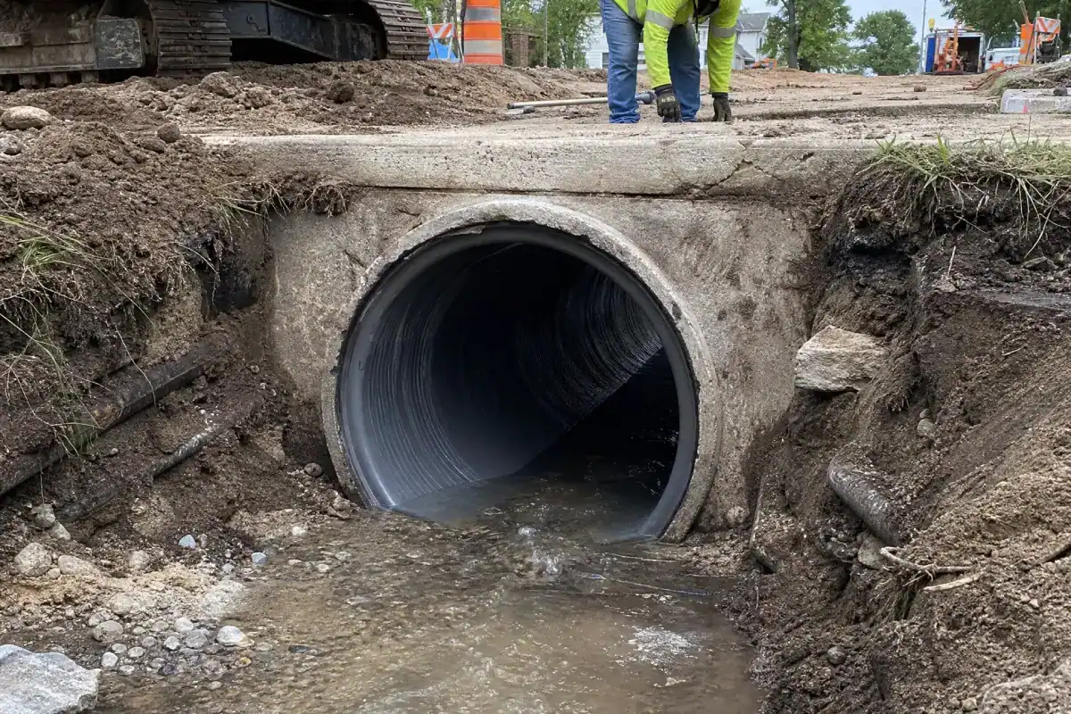 Pelican Underground LLC workers oversee a safe culvert installation to let water flow under a rural road.